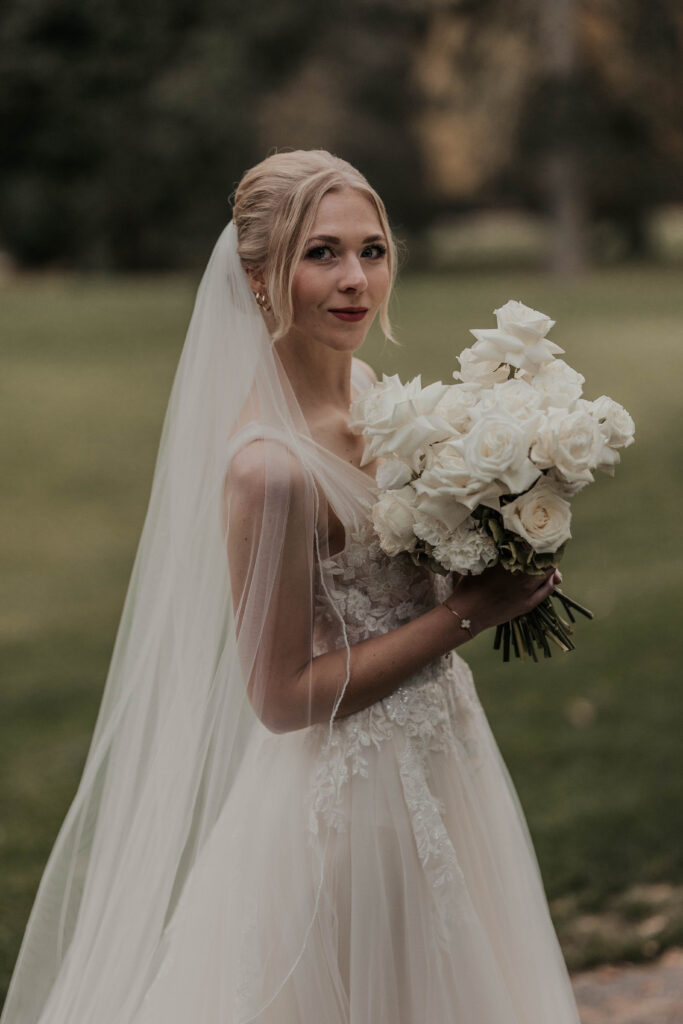 Braut mit Schleier und Brautstrauß im Brautkleid von Schleier und Spitze