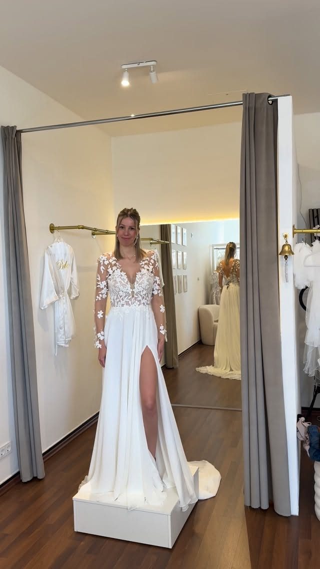 Reel: Braut im Spitzenbrautkleid mit Beinschlitz auf dem Podest